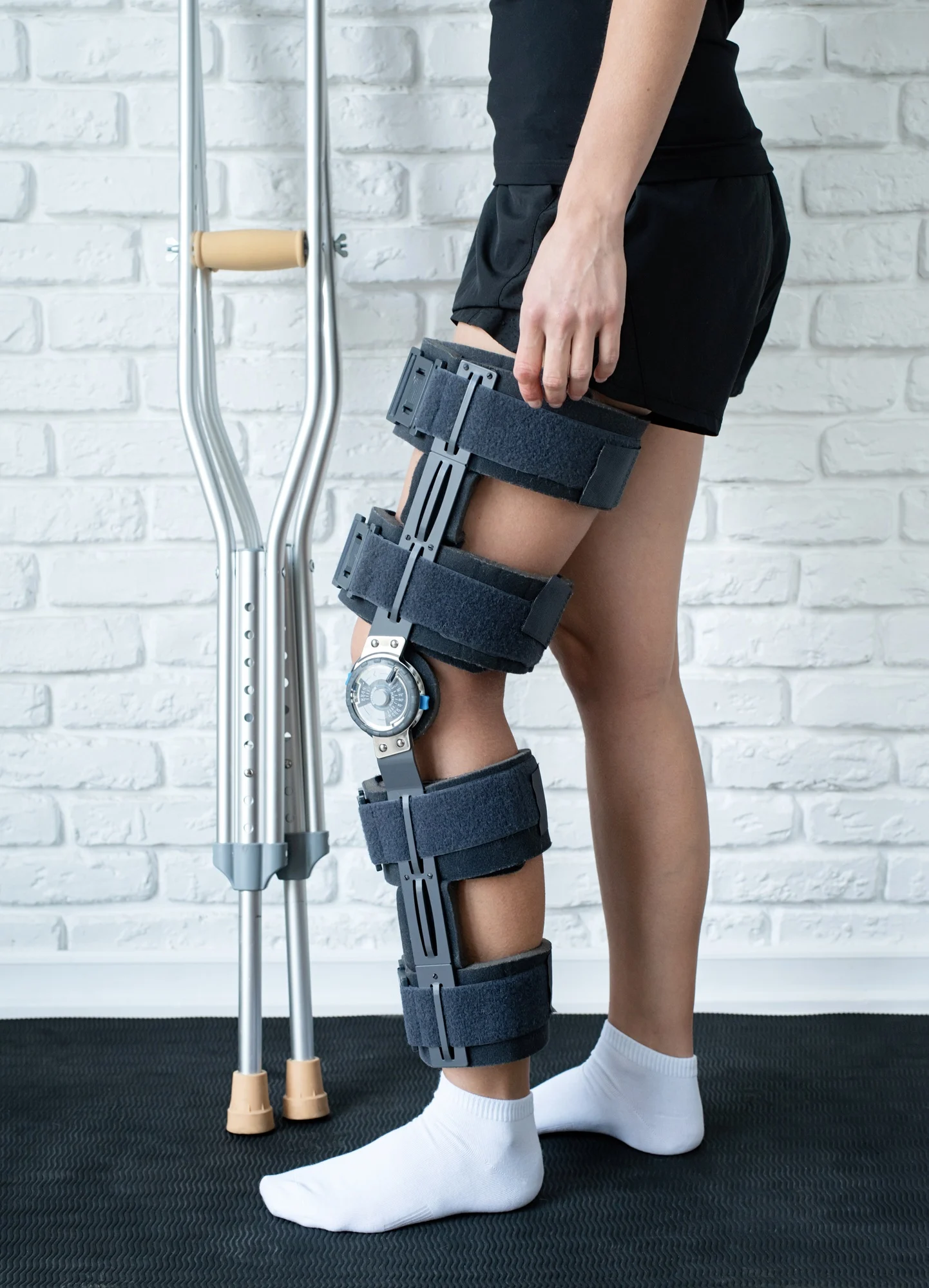 Female wearing knee orthosis or knee support brace after surgery on leg